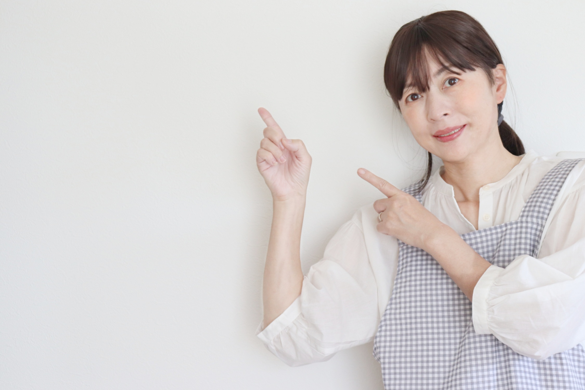女性を指を指してこちらを見ている姿